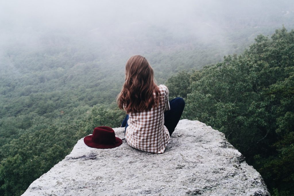 L'être vivant et sa capacité d'adaptation. Femme au sommet d'une montagne